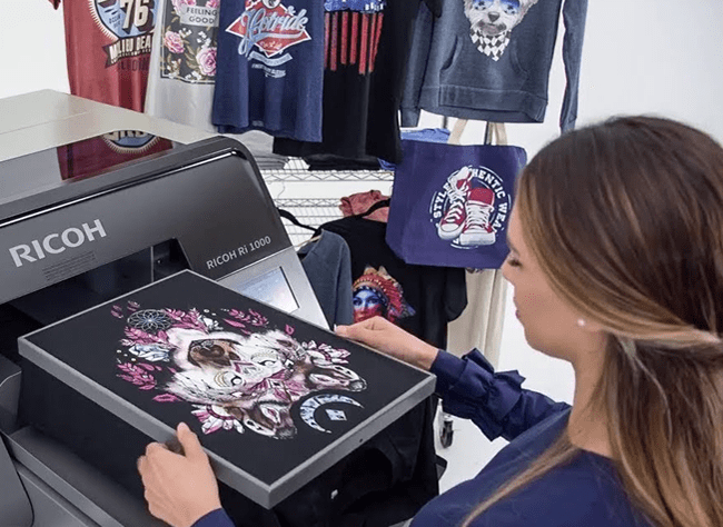 Una trabajadora usando una impresora DGT de estampar camisetas